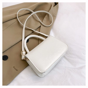 Detail of off-white saddle bag featuring smooth PU leather and gold-tone hardware