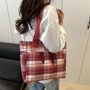 Classic red and white checkered canvas tote bag with wide shoulder straps and side pockets
