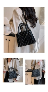 Detail of black quilted shoulder bag featuring gold hardware and adjustable strap