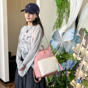 Pink and white color-blocked nylon backpack with tassels and a chic leather label