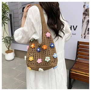 Detailed view of hand-knitted bohemian shoulder bag with colorful crochet 3D flowers