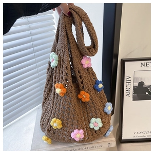 Detailed close-up of brown knit tote bag with colorful 3D crochet flower patterns