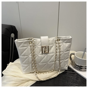 Macro view of white quilted tote bag featuring golden geometric metal buckle and chain straps