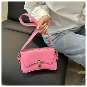 Close-up of pink leather shoulder bag with gold metal buckle and smooth texture