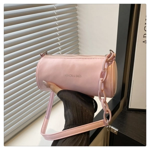Vue détaillée d'un sac baril rose avec lettrage mode et bandoulière chaîne en plastique