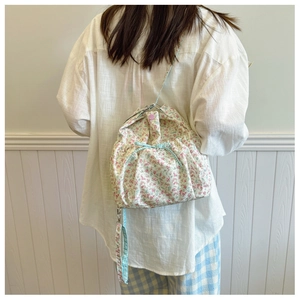 Detailed back view of a floral crossbody bag with light blue gingham bow and pink button