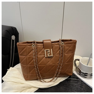 Detail of brown quilted tote bag with golden geometric buckle and chain strap