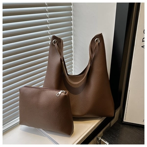 Détail du sac cabas marron foncé en cuir avec lanières à cordon et œillets argentés