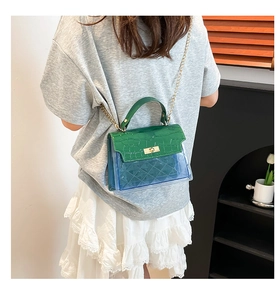 Detail view of retro Kelly style handbag with green faux skin flap and blue PVC body