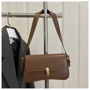 Detailed close-up of brown vintage handbag with gold oval lock on a display rack