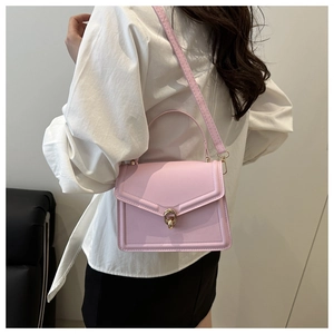 Detail of light pink crossbody bag featuring gold ring buckle and fine leather texture