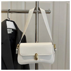 Detail shot of a white faux leather shoulder bag featuring a polished gold twist lock