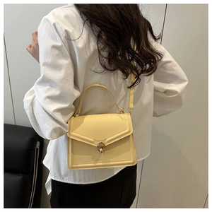 Vue arrière d'un mannequin portant un sac bandoulière crème avec fermoir rotatif doré chic