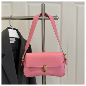 Detail of the pink leather underarm bag featuring a metallic gold buckle on the strap