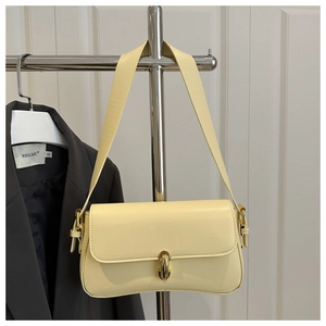 Detail view of the yellow rectangular shoulder bag featuring a gold metal buckle closure