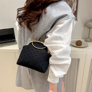 Retro black velvet polka dot bag with circular metal handle and gold chain strap