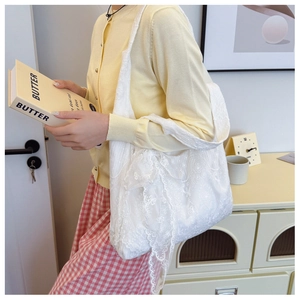 Detail of white lace floral embroidery on a large capacity tote bag for women
