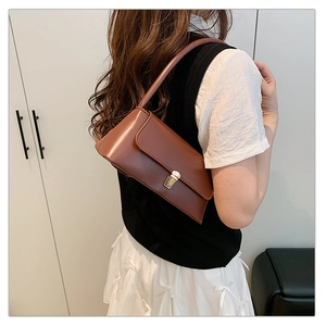 Détail d'un sac porté épaule en cuir marron avec fermoir doré vintage et texture élégante