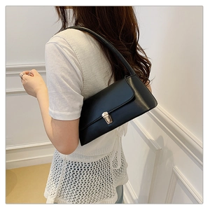 Détail d'un sac sous les aisselles en cuir noir avec fermoir en métal doré pour femmes