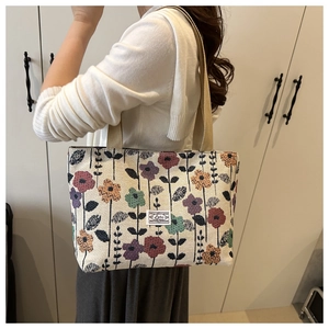 Detail of vintage knit floral tote bag with colorful embroidery and woven strap handle