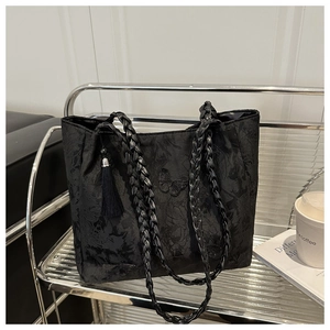 Detail of black jacquard tote bag with butterfly embroidery and woven leather straps