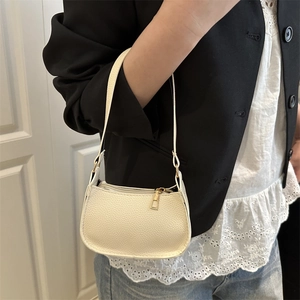 French retro cream crescent shoulder bag with lychee texture worn by a model in a suit