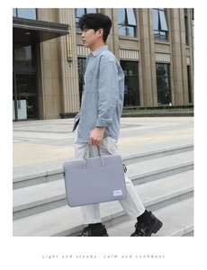 Macro shot of light gray laptop bag featuring durable fabric texture and sleek carry handles
