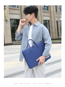 Close-up of durable navy business laptop bag with reinforced handles and white logo tag
