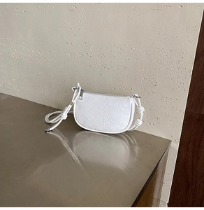 Dettaglio borsa bianca in pelle martellata con tracolla annodata e fibbia argento