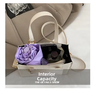 Internal capacity of beige crocodile pattern handbag showing space for umbrella and phone