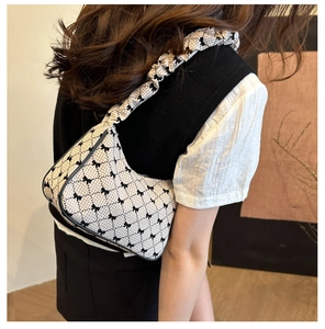 Detail of checkered shoulder bag with bow prints and stylish ruched strap detail