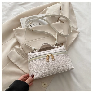 Detail of cream woven leather crossbody bag with golden dual zippers and top handle