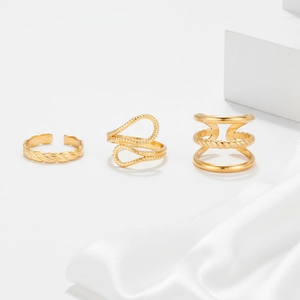 Detailed close-up of gold stainless steel rings set on elegant white silk fabric