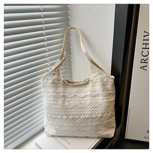Detailed texture of multilayered off-white lace tote bag with delicate floral patterns
