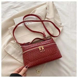 Detail of dark red woven textured box bag with gold double zippers and top handle