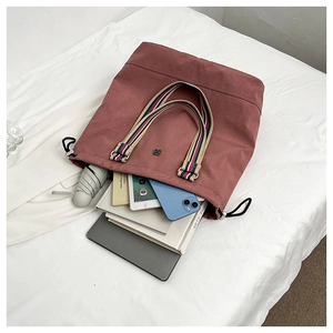 Detailed interior view of a large canvas tote bag with striped handles and ample storage space