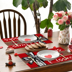 Détail de sets de table en lin avec cœurs et nœuds écossais sur une table en boi