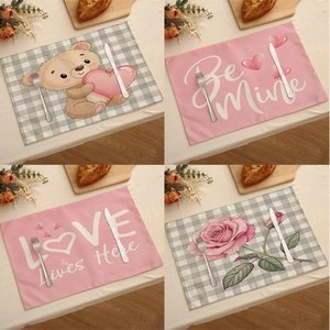 Gros plan de quatre sets de table en lin pour la Saint-Valentin aux motifs cœurs