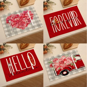Détail de quatre sets de table en lin pour la Saint-Valentin avec motifs cœurs et camions