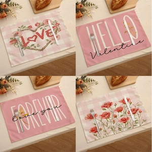 Vue détaillée de quatre sets de table en lin avec motifs de cœur et slogans d'amour