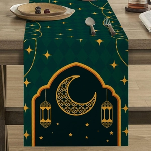 Detail of dark green table runner with gold moon and lantern patterns for festive decor