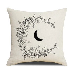Linen cushion cover with black crescent moon and floral wreath on a cream background