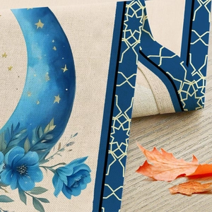 Linen Ramadan table runner with blue moon and star print on a light wooden background