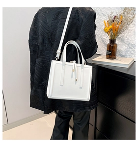 Détail d'un sac cabas carré blanc minimaliste avec sangles décoratives et poignées