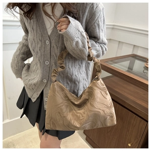 Close-up of marble pattern shoulder bag with a stylish scrunched pleated handle