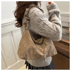 Detail of coffee marble pattern shoulder bag with soft cloud-like pleated strap detail