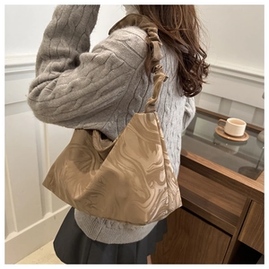 Detail of crossbody cloud bag showing marble texture fabric and pleated shoulder strap