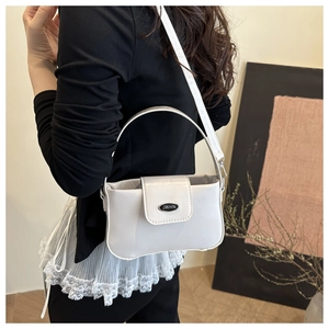 Detail of white PU leather crossbody bag with metal logo buckle and adjustable strap