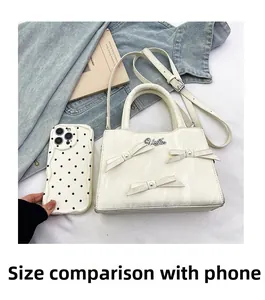 Vue détaillée du sac à main blanc avec nœuds élégants et détails de perles