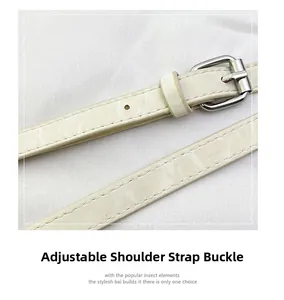 Détail de la boucle argentée réglable sur bandoulière en cuir blanc cassé